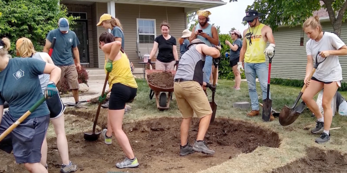 people with shovels in front of home